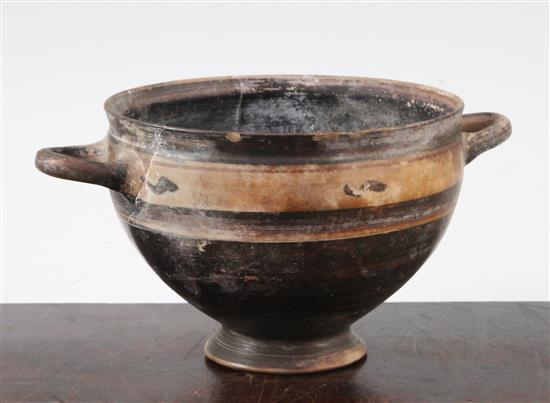 A Greek black slip decorated skyphos, Apulia, c.4th century BC, 22.5cm, broken and re-assembled